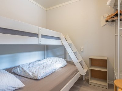 Bedroom with bunk bed and wooden shelf.