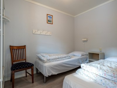 Twin bedroom with two single beds and wooden chair.