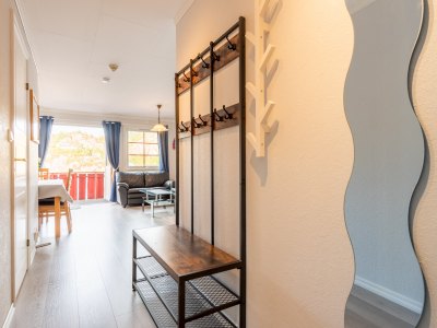 Hallway with mirror and coat rack.