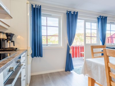 Kitchen with large windows and blue curtains.