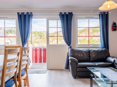 Living room with large windows, blue curtains, and sofa.