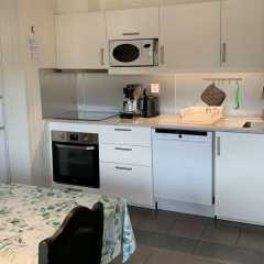Full kitchen with appliances and dining table.