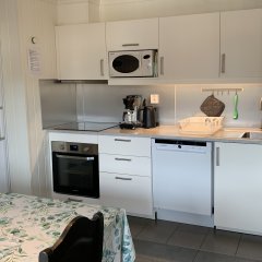 Modern apartment kitchen with white cabinets and appliances.