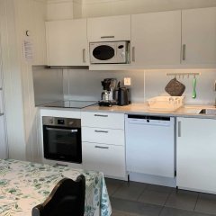 Modern apartment kitchen with white cabinets and appliances.