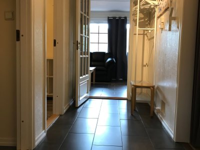 Hallway entrance with coat rack and open door.