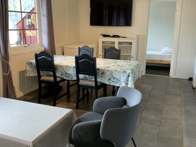 Dining area with table, chairs, and wall-mounted TV.