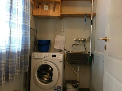 Utility room with washing machine and sink.
