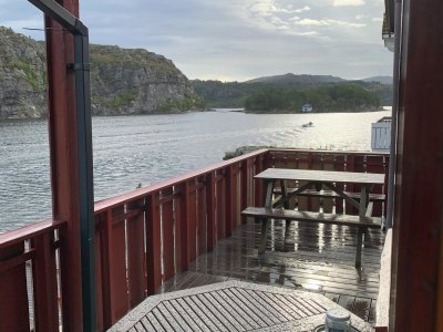 Balcony with railing and fjord view.