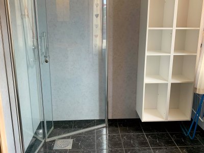 Bathroom with shower and storage shelves.