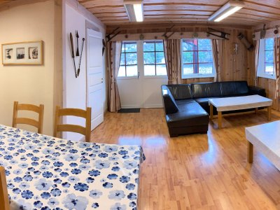 Living room with sofa, dining table, and windows.