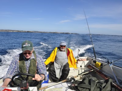 Group fishing from motorboat at sea.