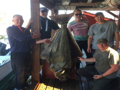 Guests displaying giant halibut catch.