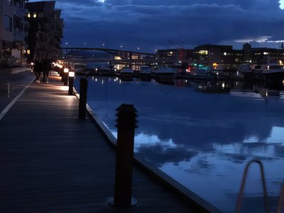 Night view of Bergen harbor with reflections on the water.
