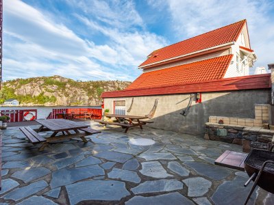 Outdoor terrace with stone patio and grill.