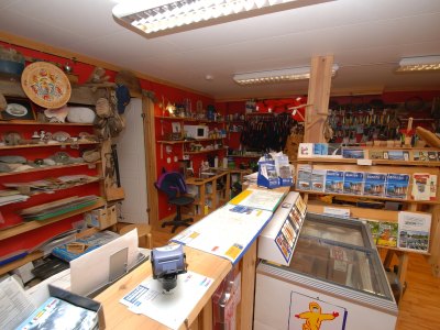 Interior of fishing gear shop with counter and shelves.